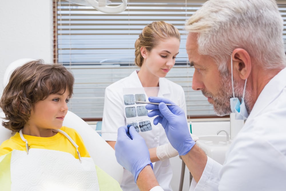 Pediatric dentist showing little boy his mouth xray