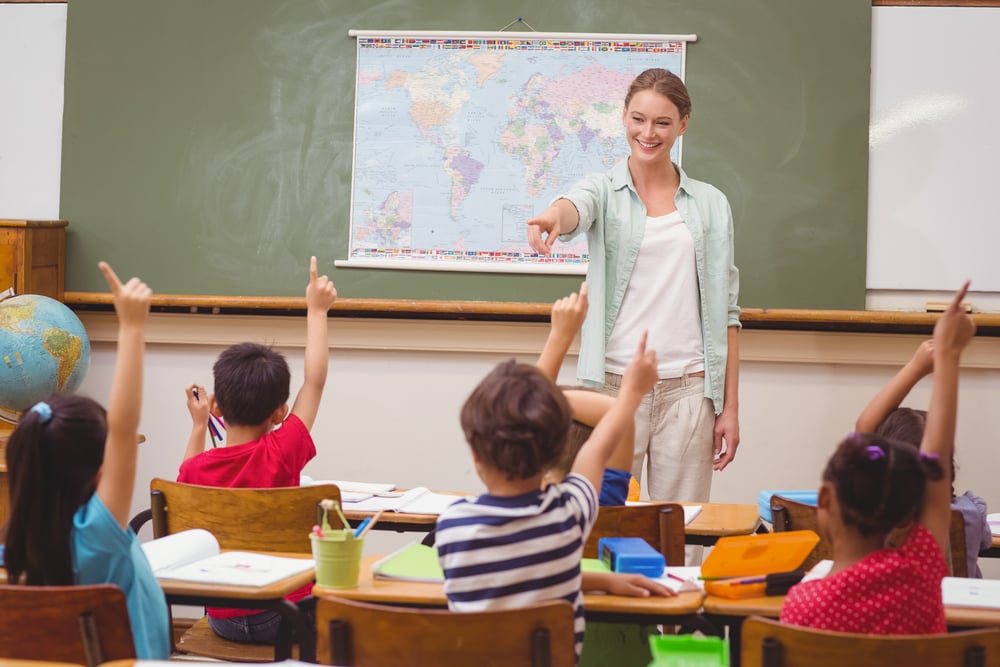 Students raising hand in classroom