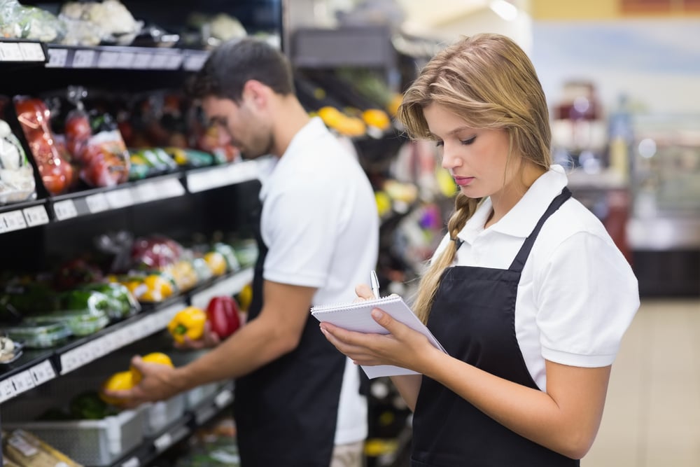 Staff stocking shelves at supermarket