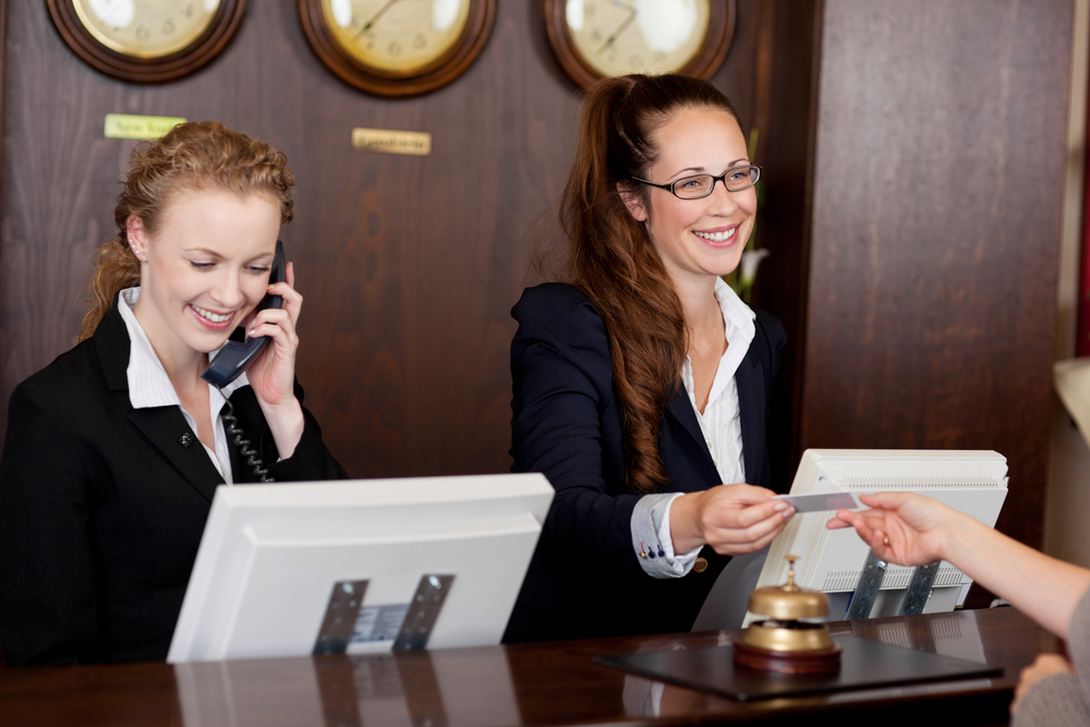 Two receptionists at hotel reception desk