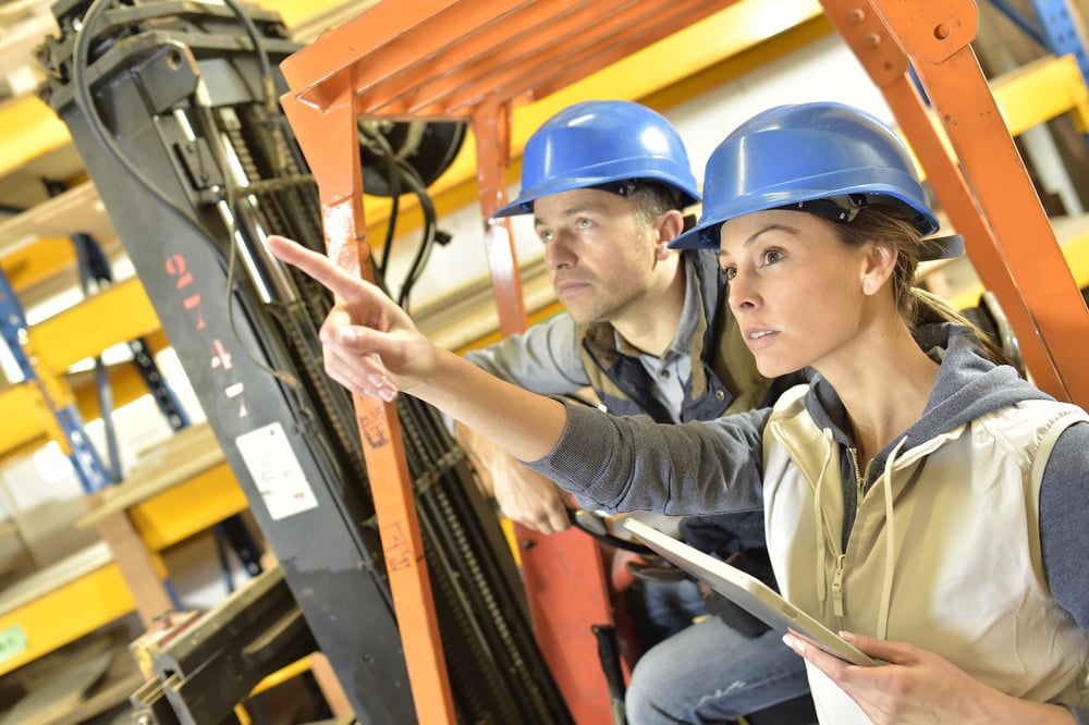 Operator with overseer working in warehouse